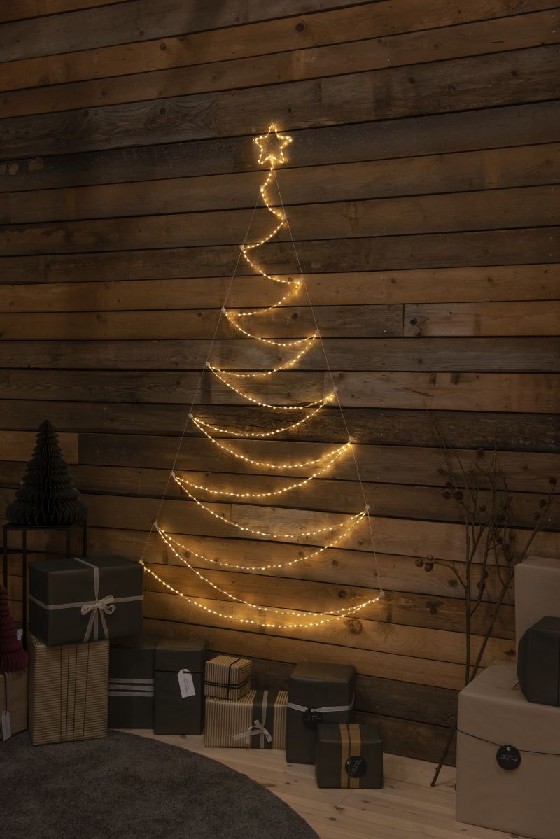 Der LED Metallweihnachtsbaum vor einer Holzwand