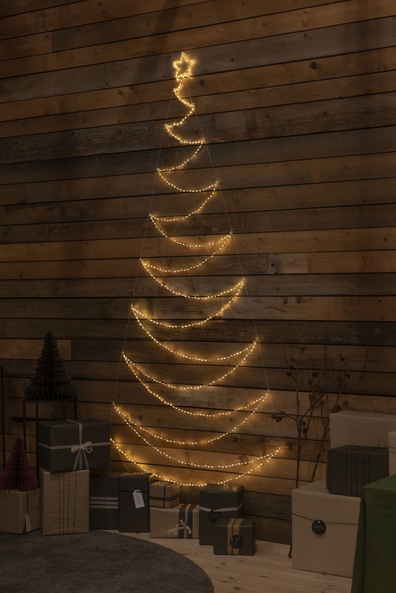 Der Metallweihnachtsbaum vor einer Holzwand
